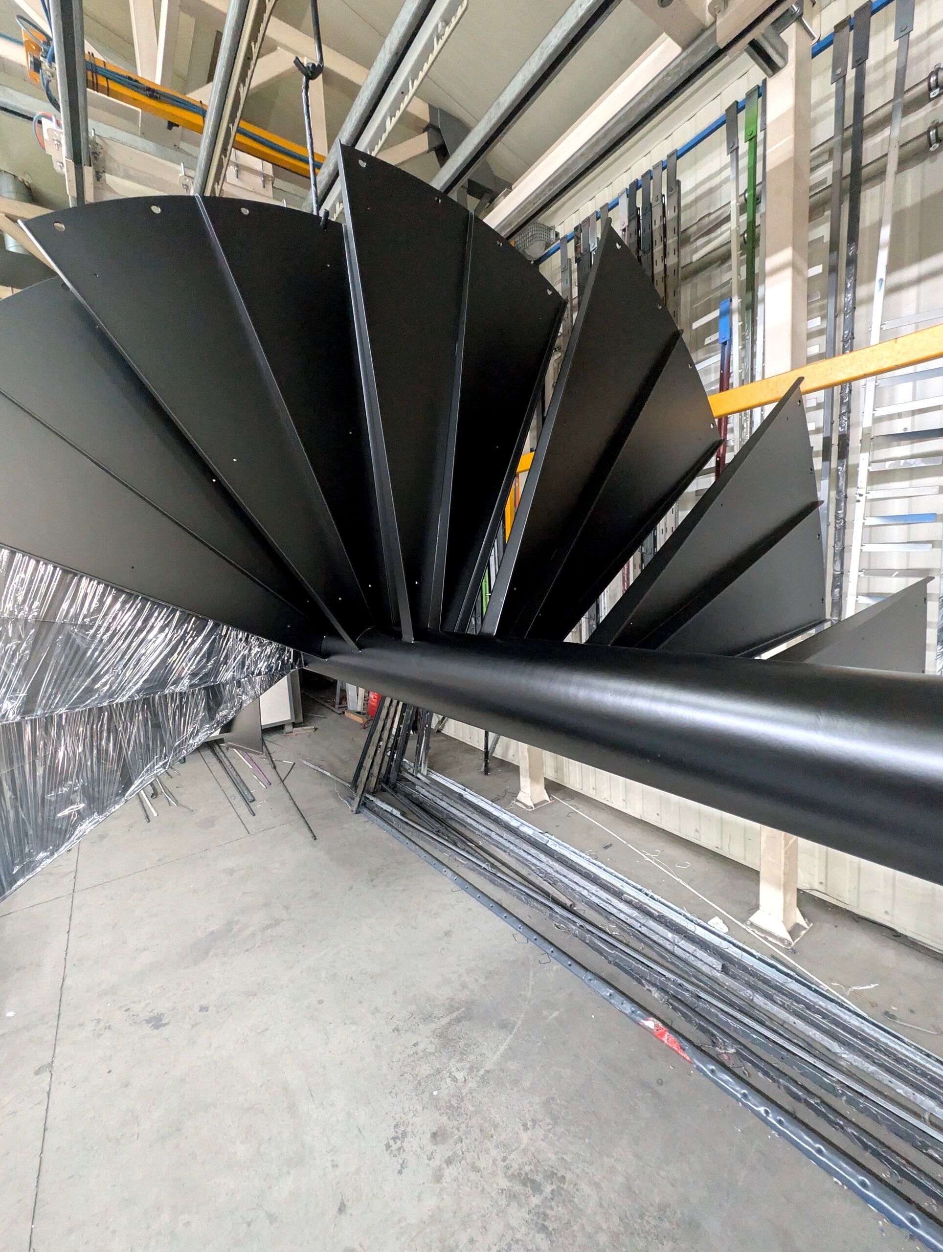 Schody spiralne stalowe po malowaniu proszkowym RAL 9005 – zbliżenie na jednolitą czarną powłokę, element wielkogabarytowy do 8 m.