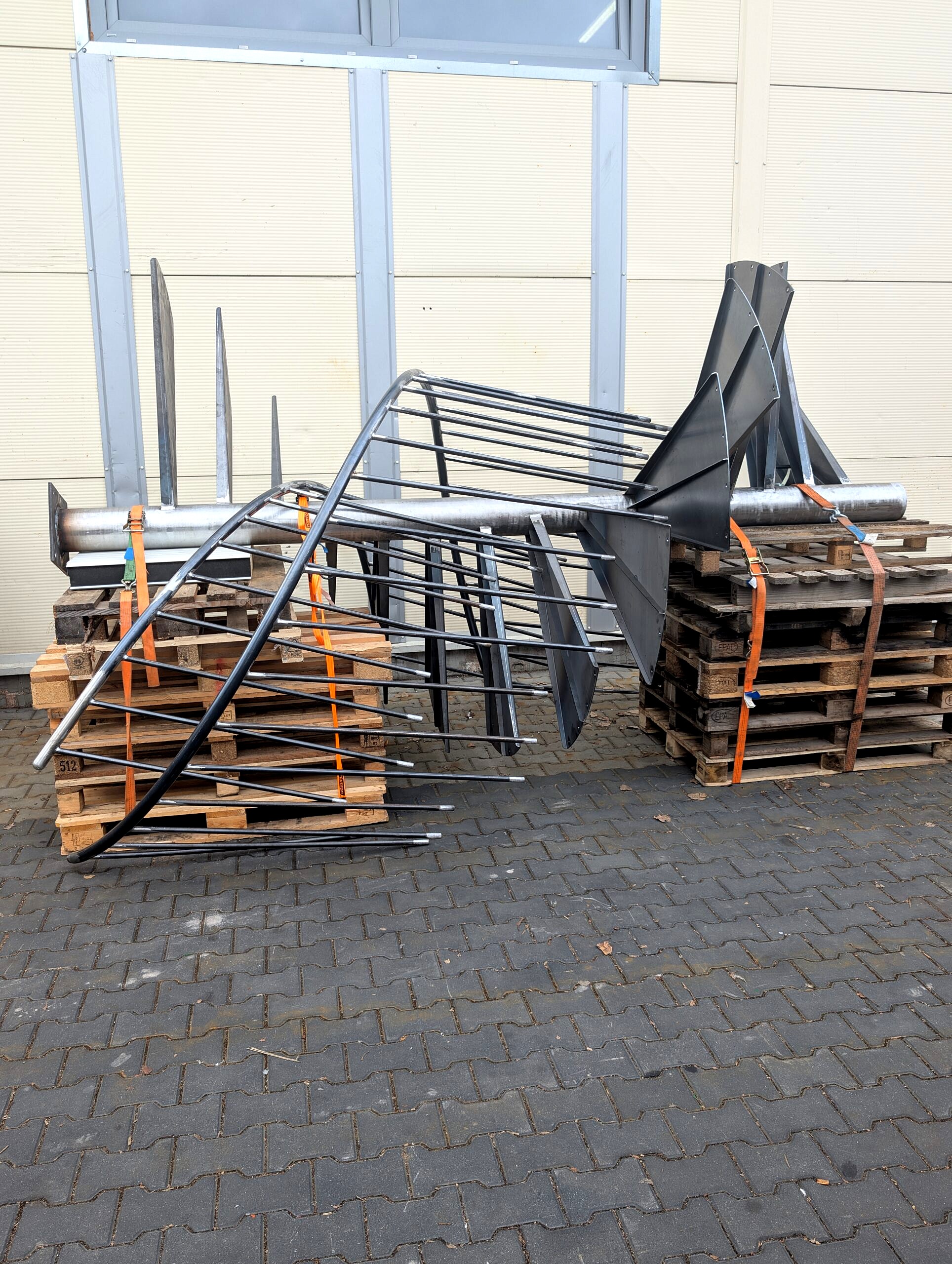 Wielkogabarytowe schody spiralne z balustradą na paletach, przed renowacją — przygotowanie do śrutowania i malowania proszkowego w kolorze RAL 9005 (element do 8 m).