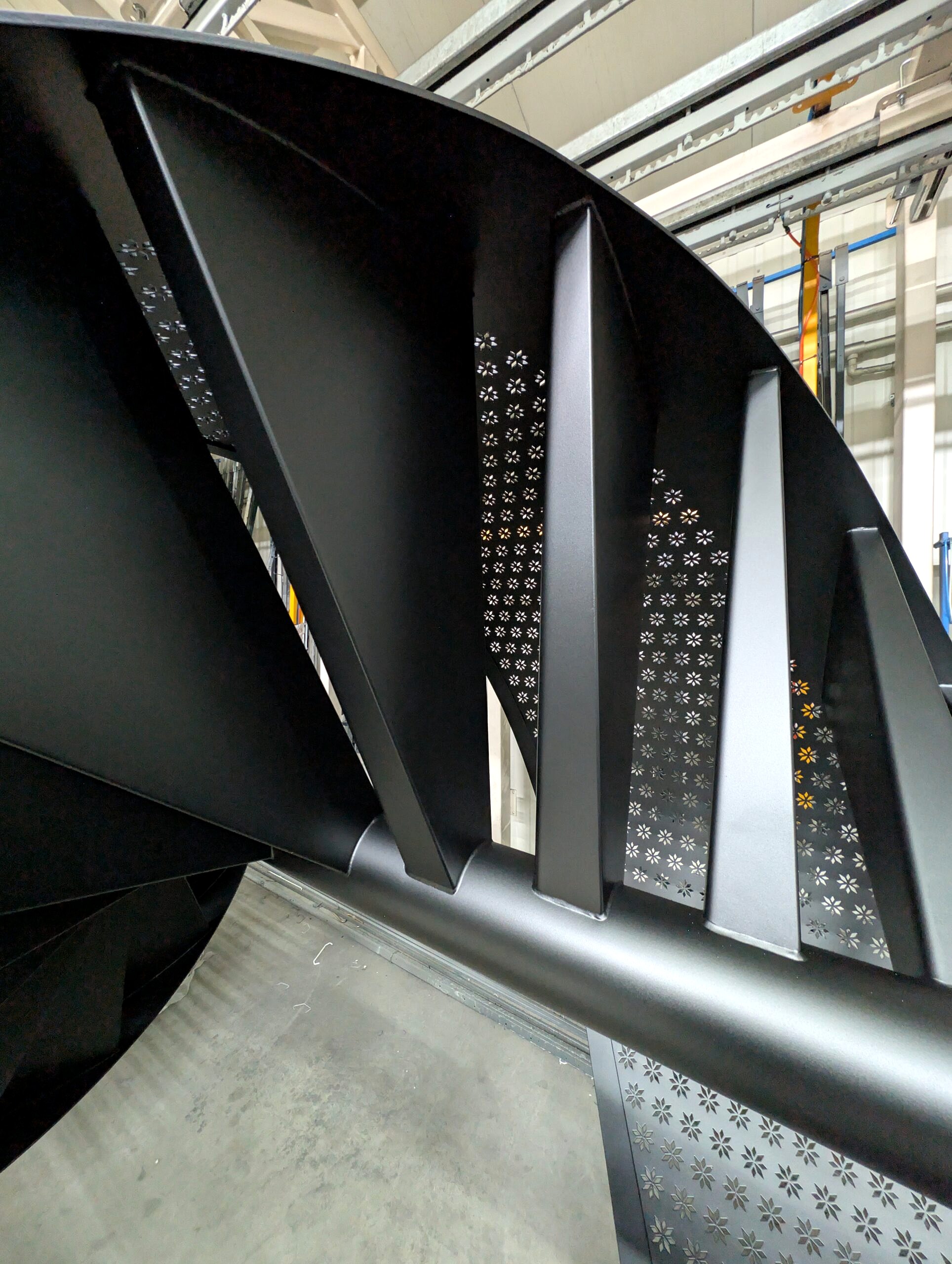 Schody spiralne po malowaniu proszkowym RAL 9005 – czarna drobna struktura na stopniach i perforacji