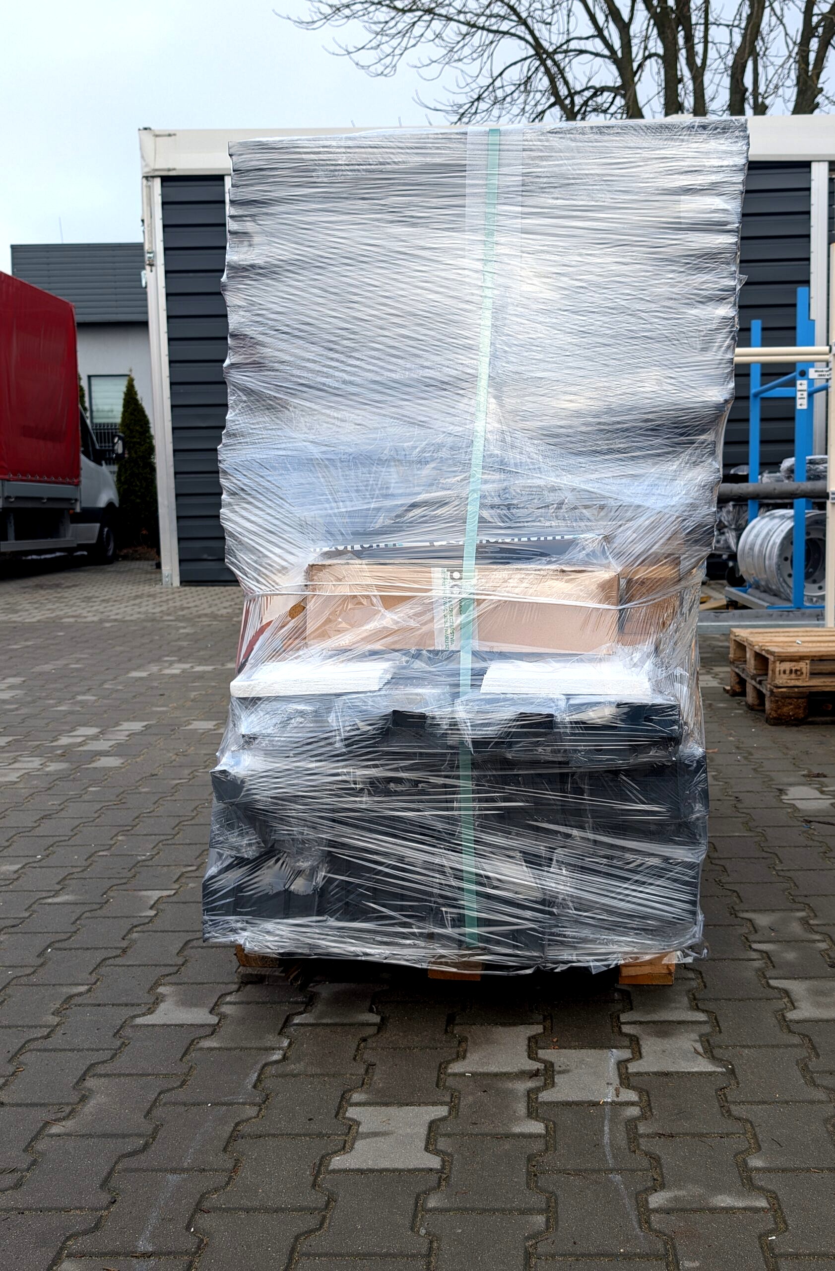 Paleta z elementami metalowymi owinięta folią stretch i spięta taśmą transportową, przygotowana do wysyłki w Lakierni Koczargi