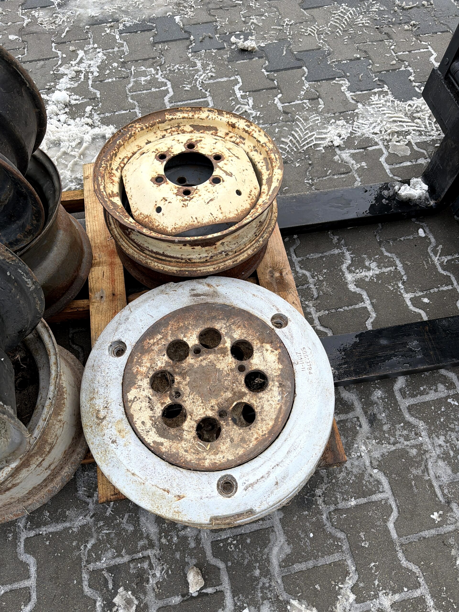 Felgi i elementy kół ciągnikowych przed renowacją – skorodowane części maszyn rolniczych