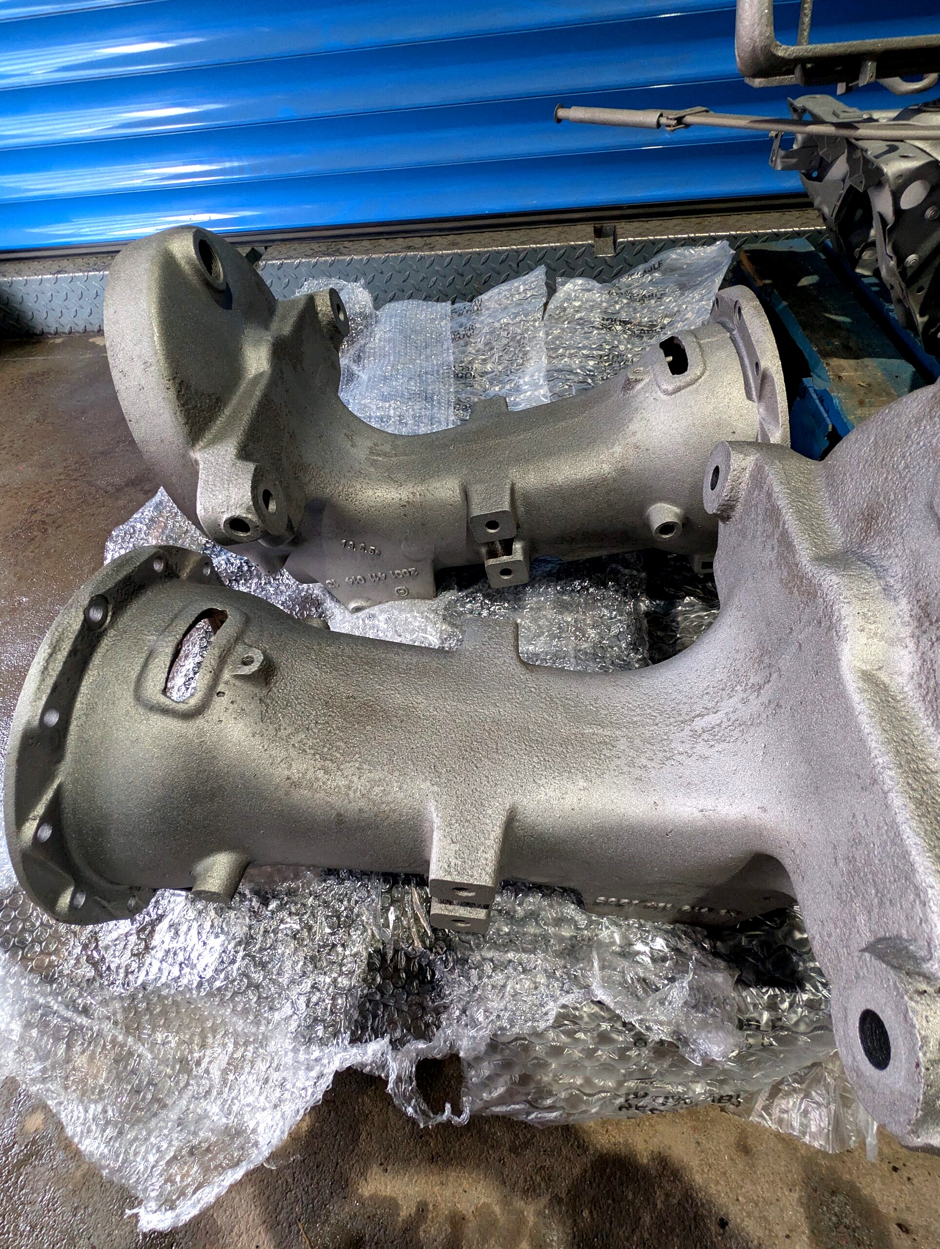 Oczyszczone metalowe odlewy traktora po śrutowaniu przygotowane do renowacji